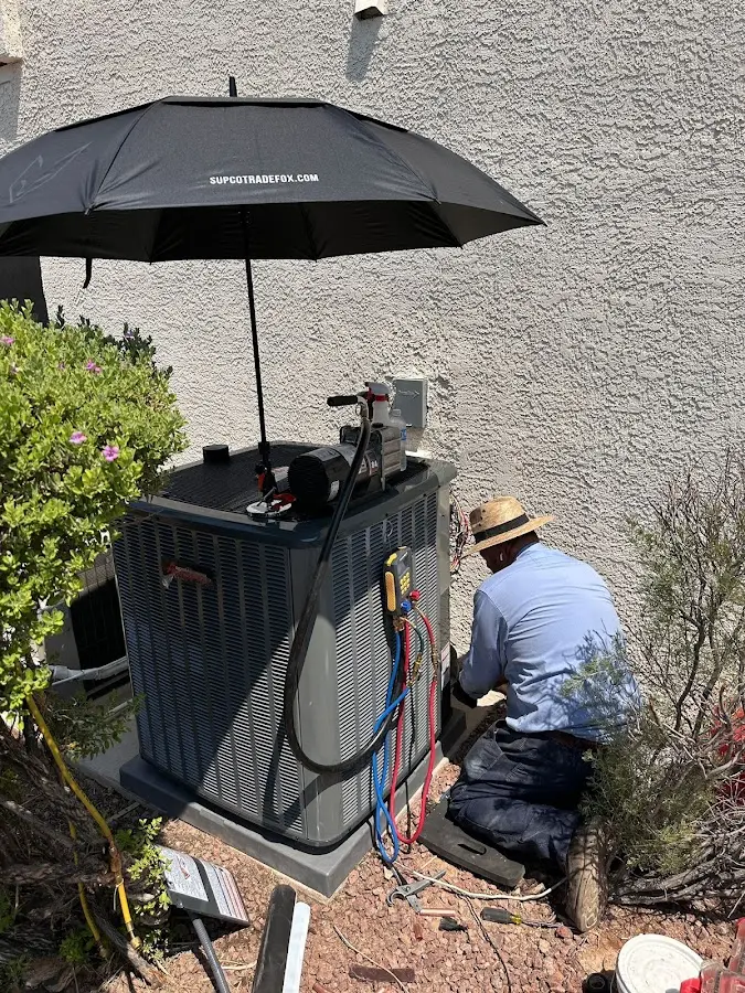 HVAC technician performing outdoor AC maintenance in Great Falls