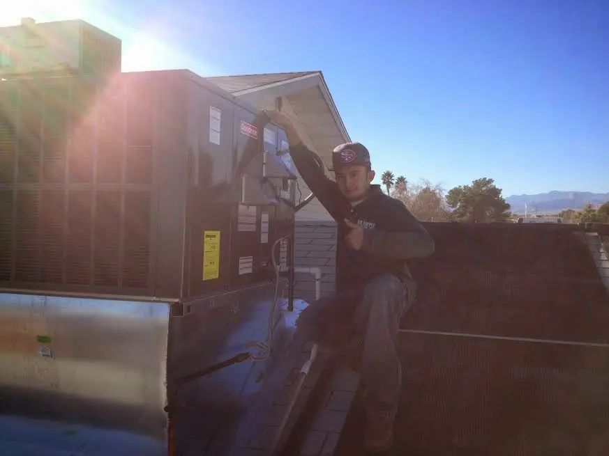 HVAC technician performing AC Tune-Up on a rooftop unit in Great Falls